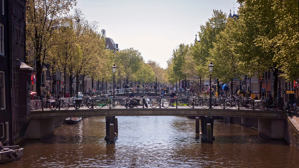 Romantic couple crossing Amsterdam's canal bridge