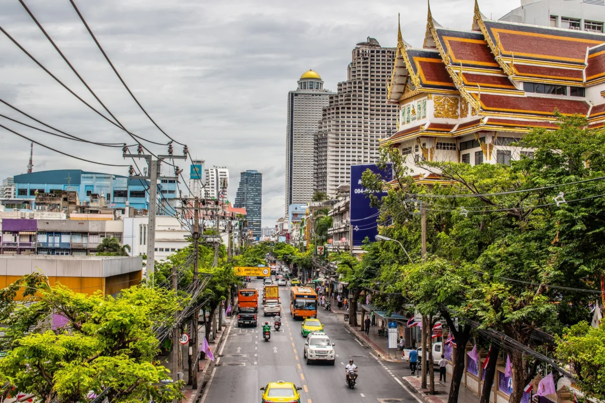 A vibrant street market in Bangkok with the city skyline in the background