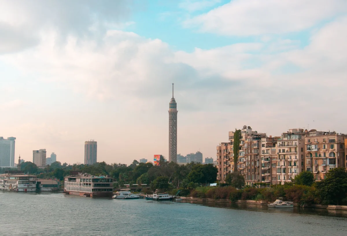 A panoramic view of Cairo's skyline with the iconic pyramids in the background