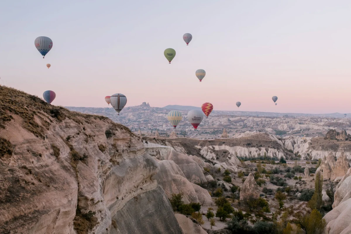 Hot air balloons floating over the scenic landscape of Cappadocia