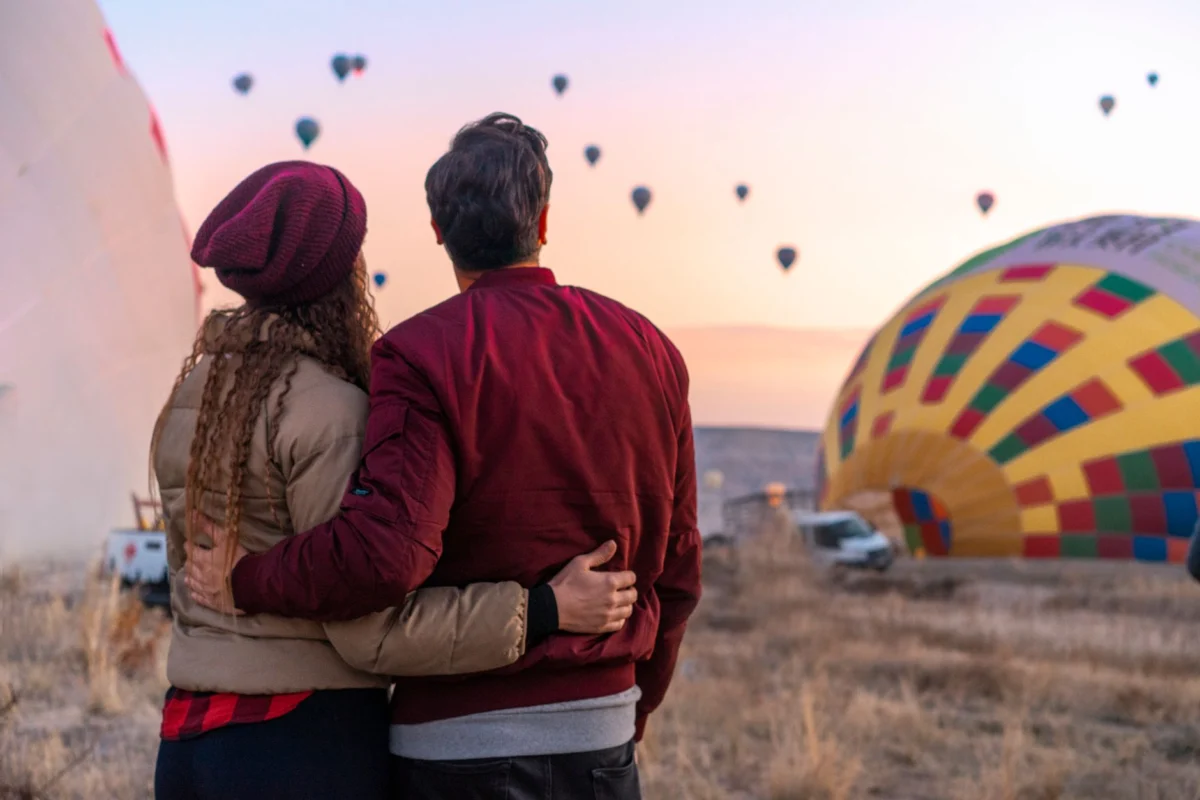 Hot air balloons floating over Cappadocia's landscape at sunset