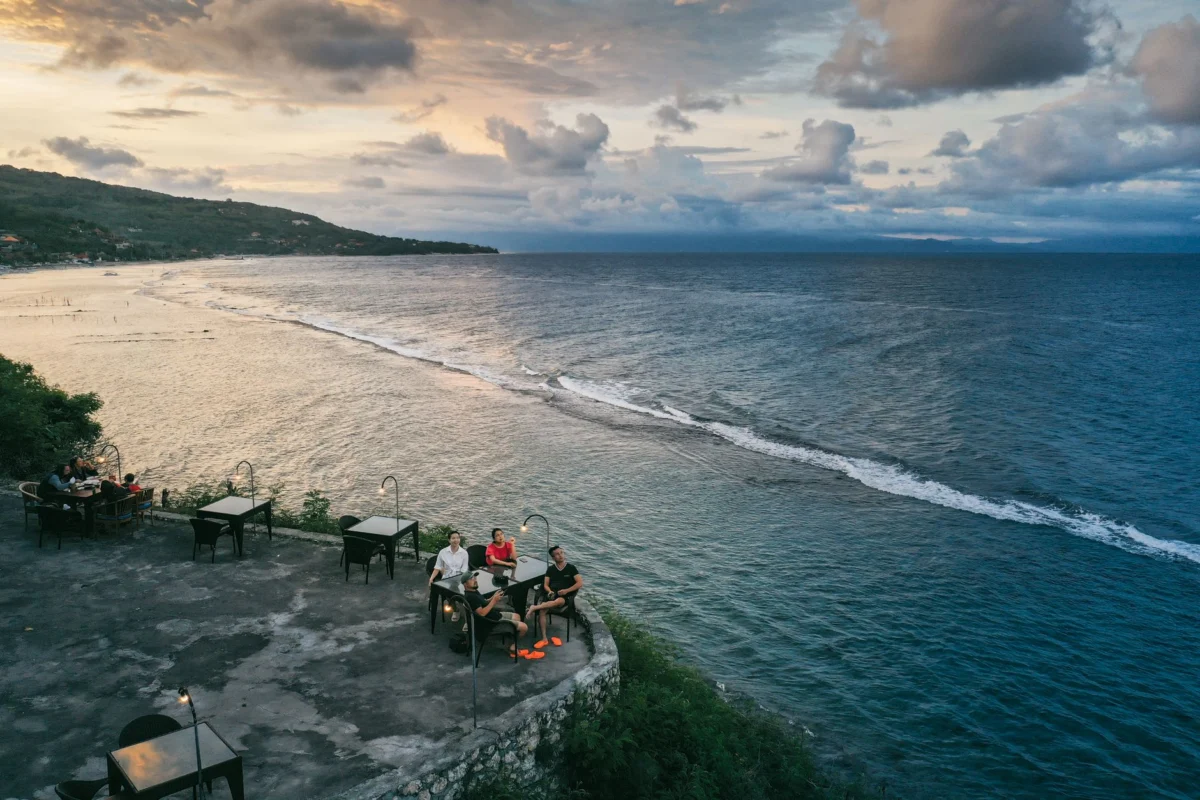 Couples dining by candlelight in Bali with tropical backdrop
