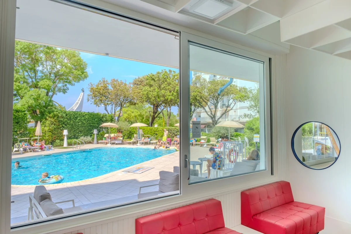 A family enjoying a hotel pool in Rome under the blue sky