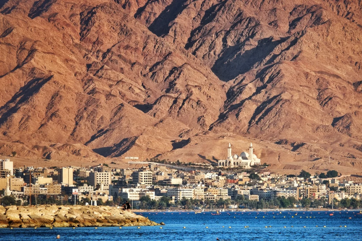A panoramic view of Aqaba with a colorful sunset sky