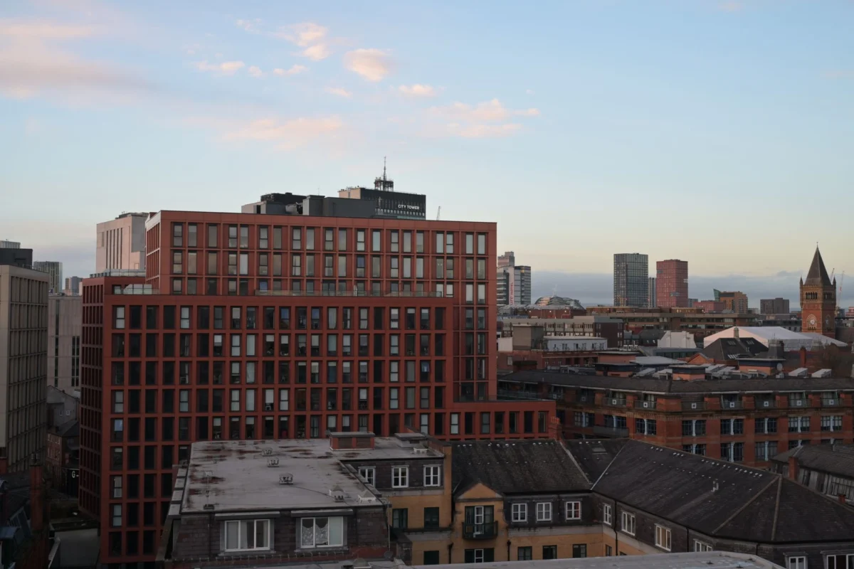 Panoramic Manchester skyline at sunset showcasing iconic city landmarks